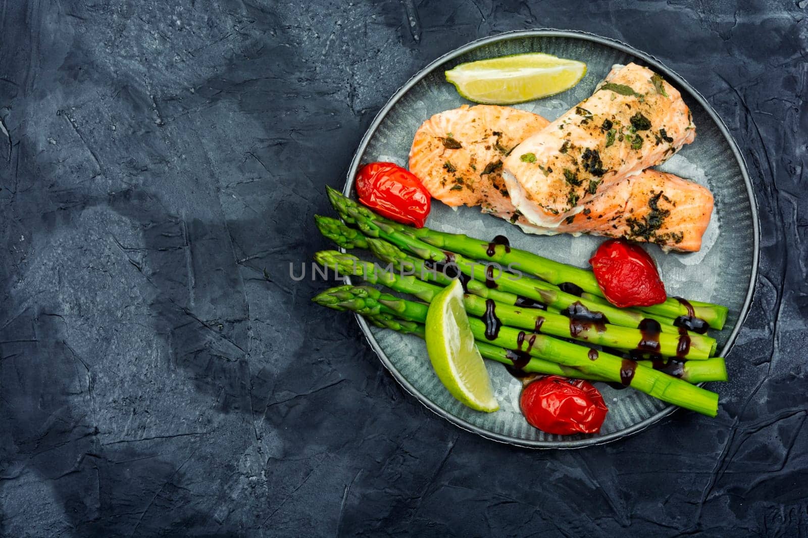 Tasty dish of trout, asparagus and tomato. Space for text.