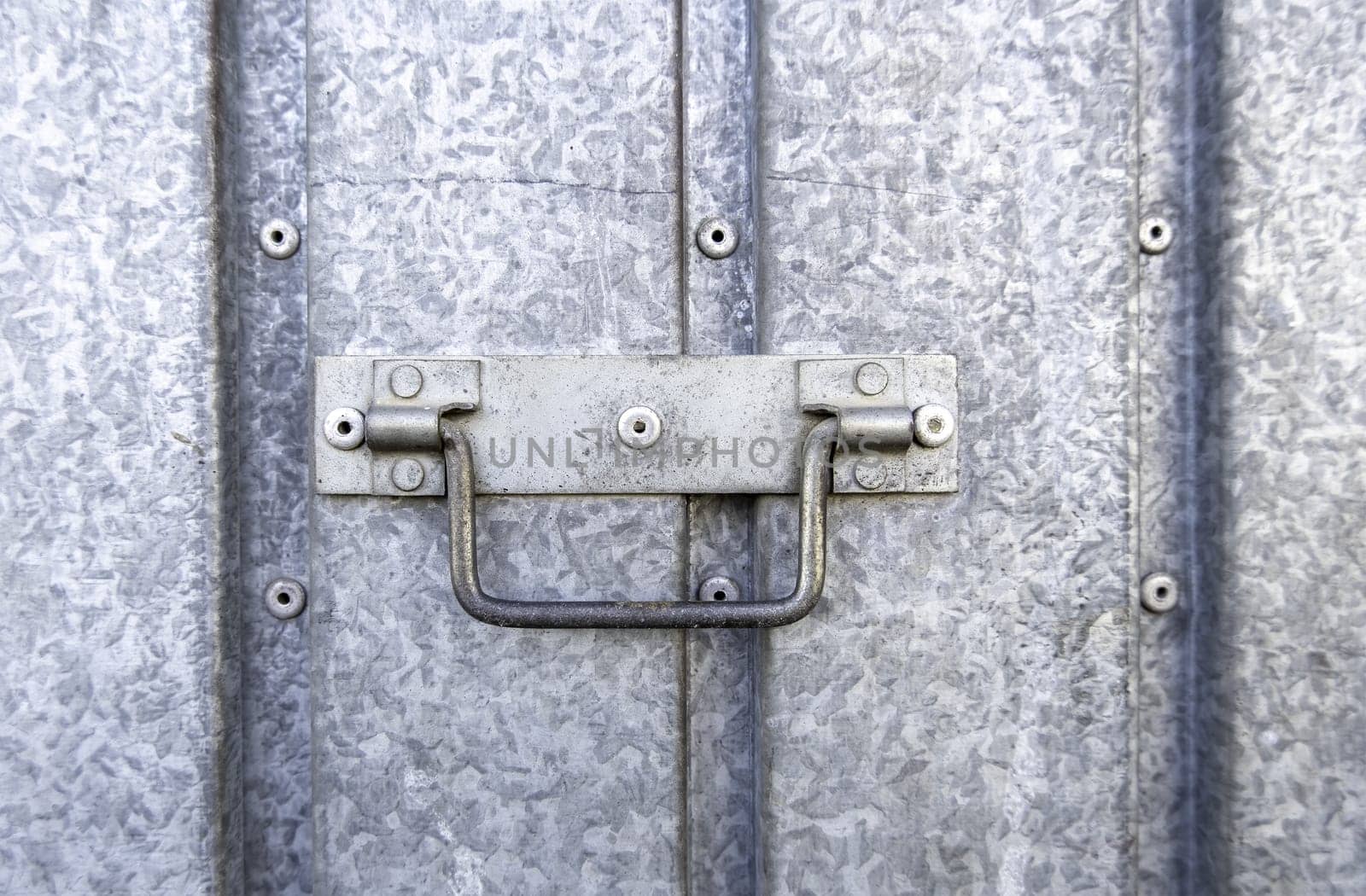 Detail of a metal handle to open and close a door on the street