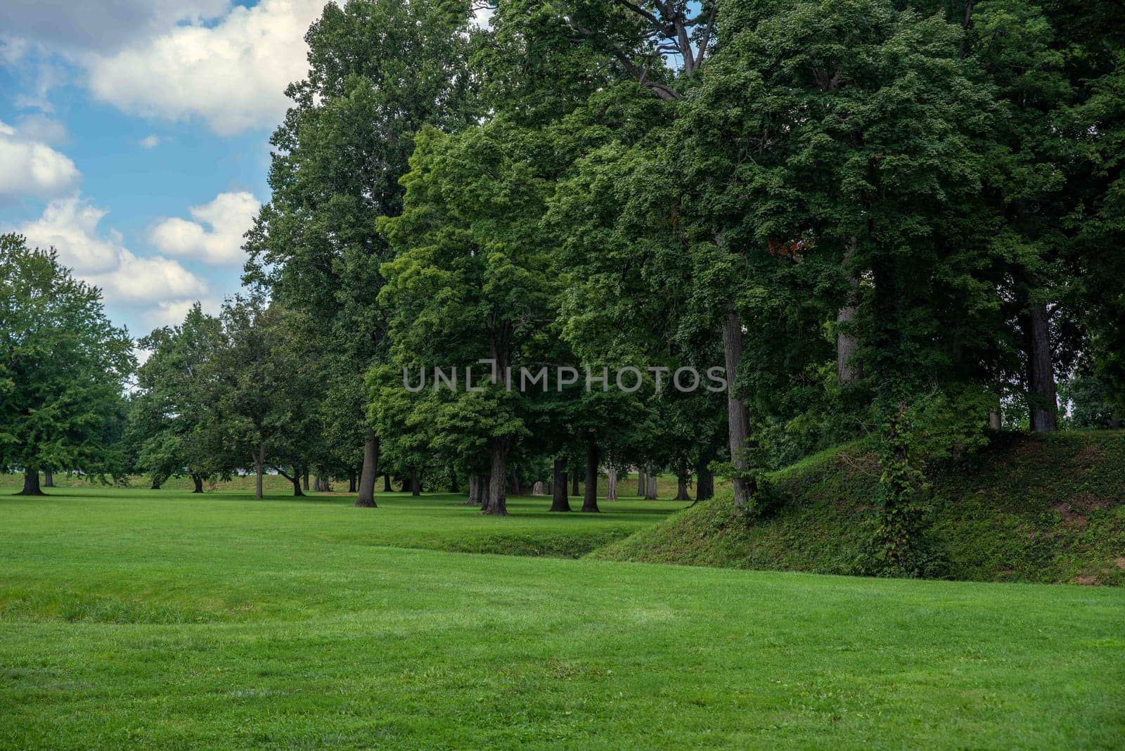 Entrance to the Great Circle at the Newark Earthworks built by prehistoric indigenous people in Ohio. Break in the circle opens to the interior. Green grass, sunny outdoors with no people and copy space. the Great Circle at the Newark Earthworks built by prehistoric indigenous people in Ohio. Green grass, sunny outdoors with no people and copy space.