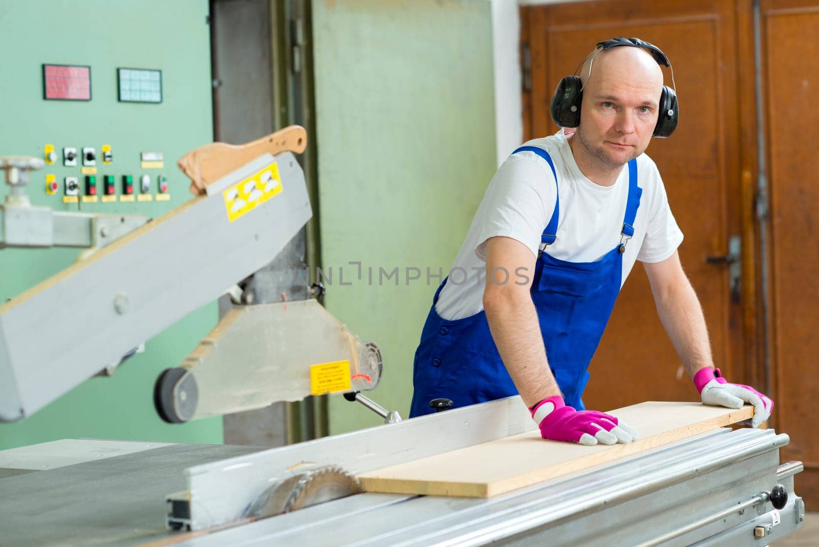 worker with ear protector in a carpenter's workshop