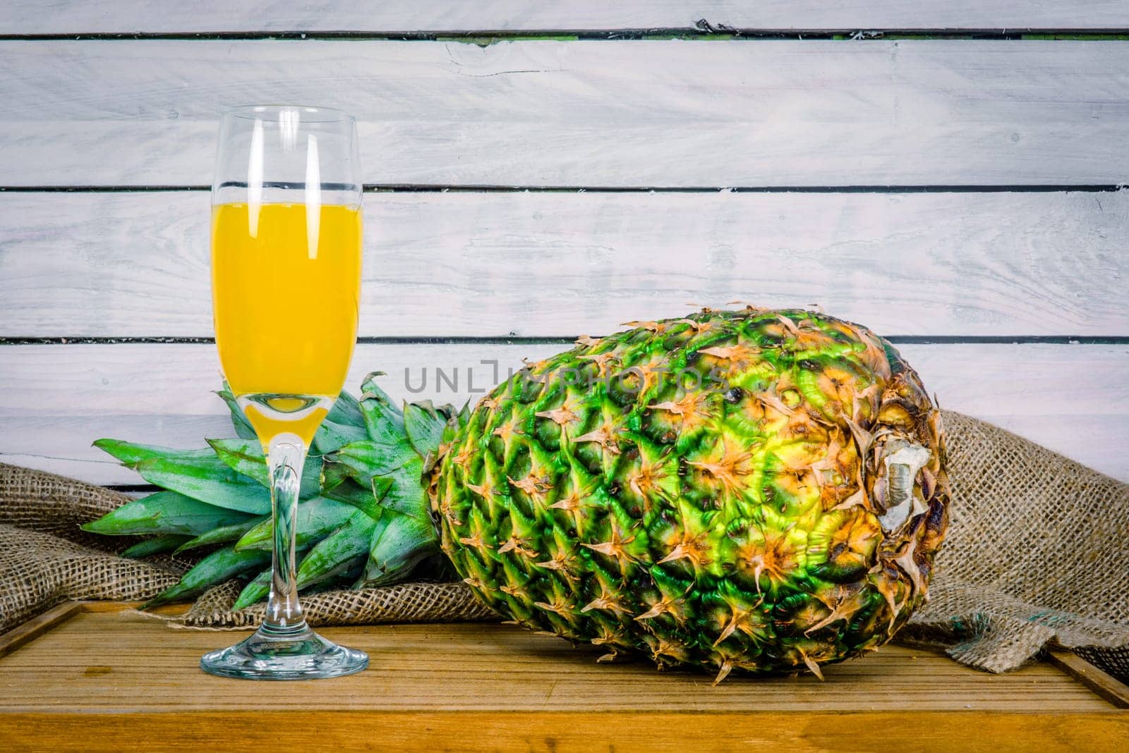 Pineapple fruit and juice on a wooden table