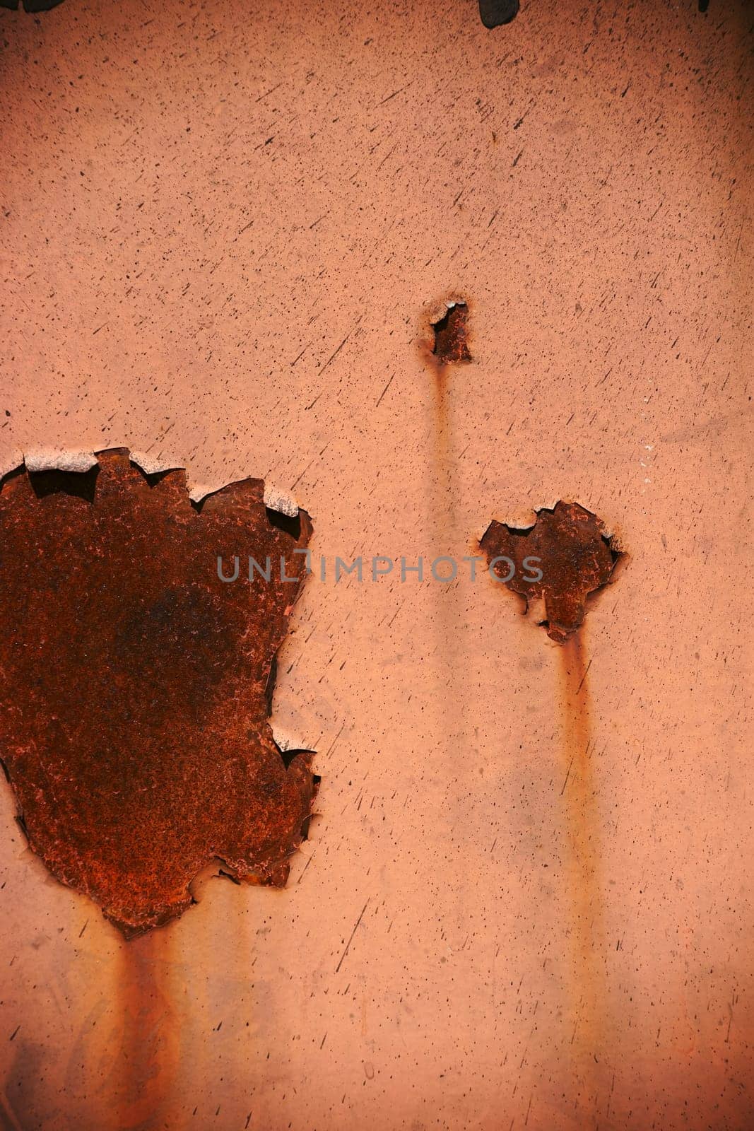 Rust stains in different sizes and with different structures on a sheet of steel.