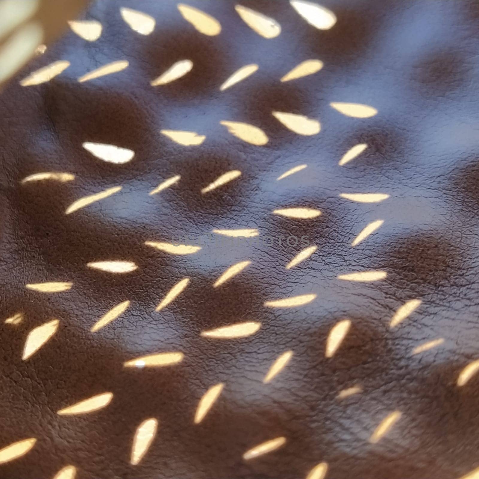 Sunbeams reflecting the sun through a stencil. Beige genuine leather texture on the sole of summer sandals. Ergonomic indentation in the insole to prevent flat feet.