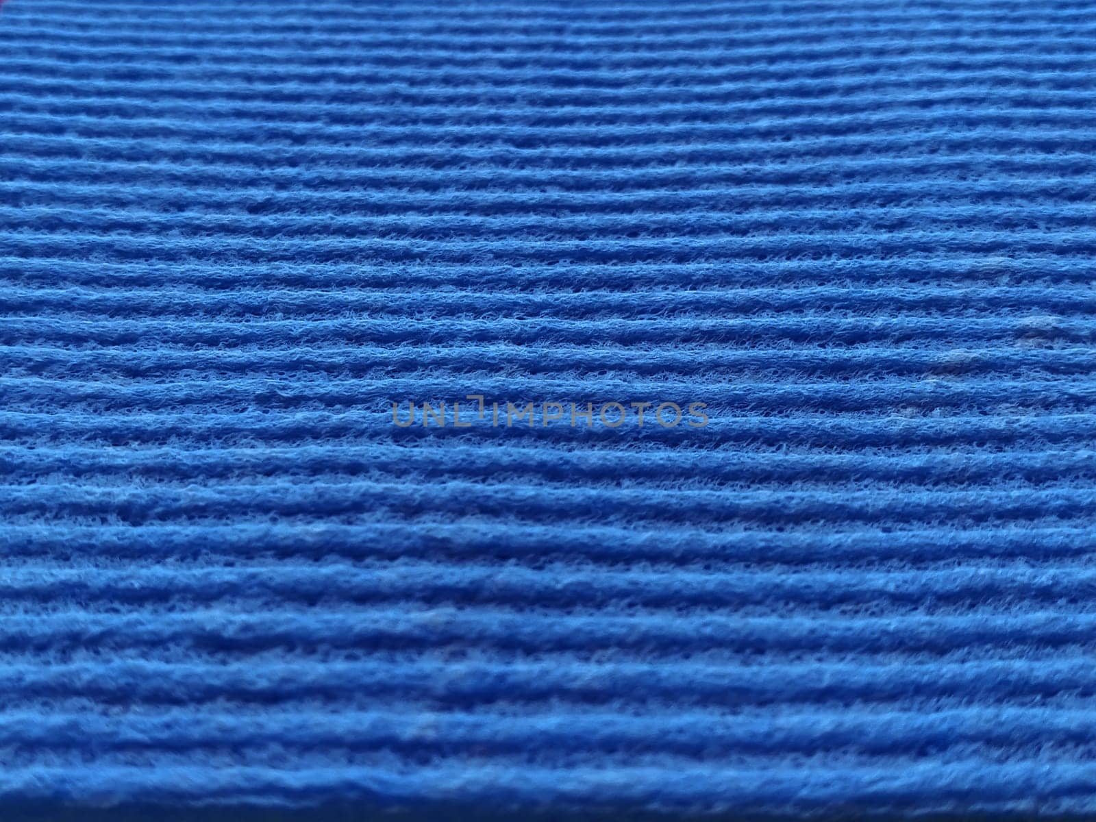 Blue striped ribbed fabric. Close-up shot of a dish washing sponge or microfiber cloth. Blur around the edges.