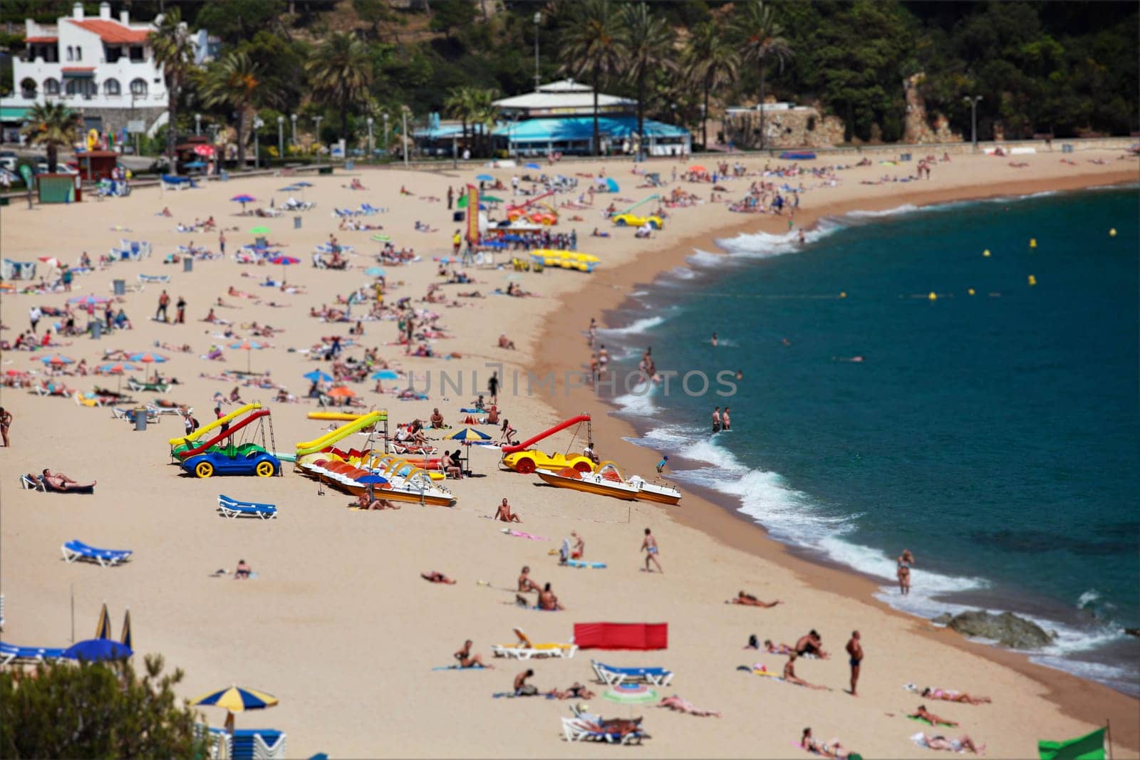 beach, many people relax and sunbathe on the shores of the warm sea, summer lagoon, palm trees