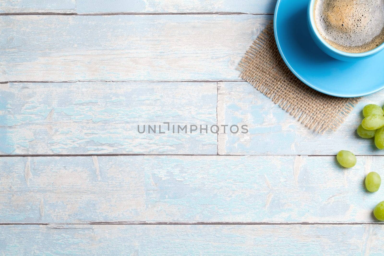 coffee cup with grapes and a wooden background