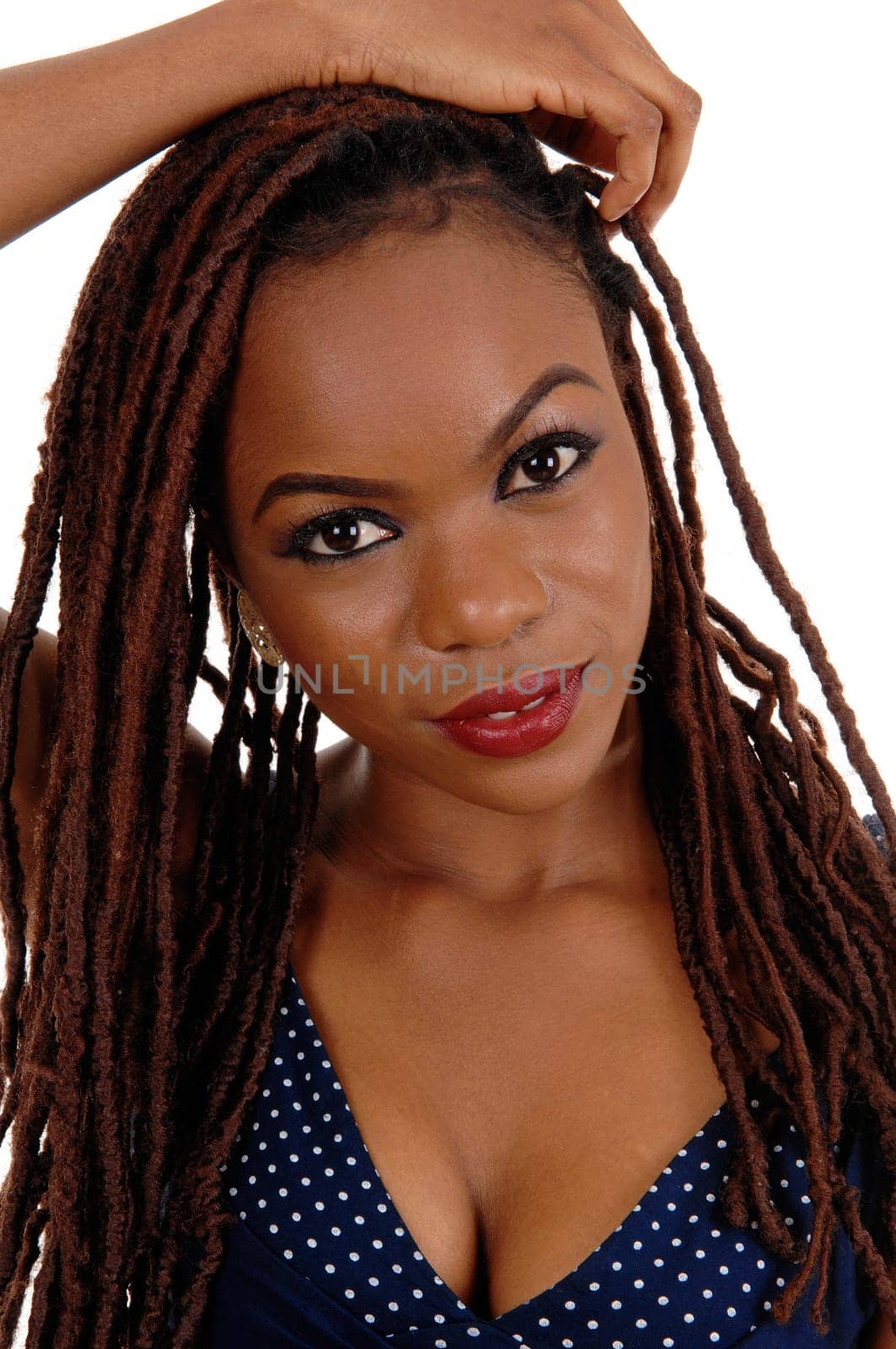 A beautiful young African American woman with long braided brown hair,.with one hand on her head, isolated for white background..