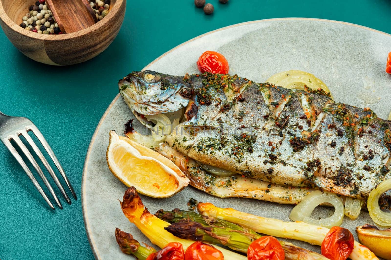 Delicious trout fish baked with white asparagus on wooden table