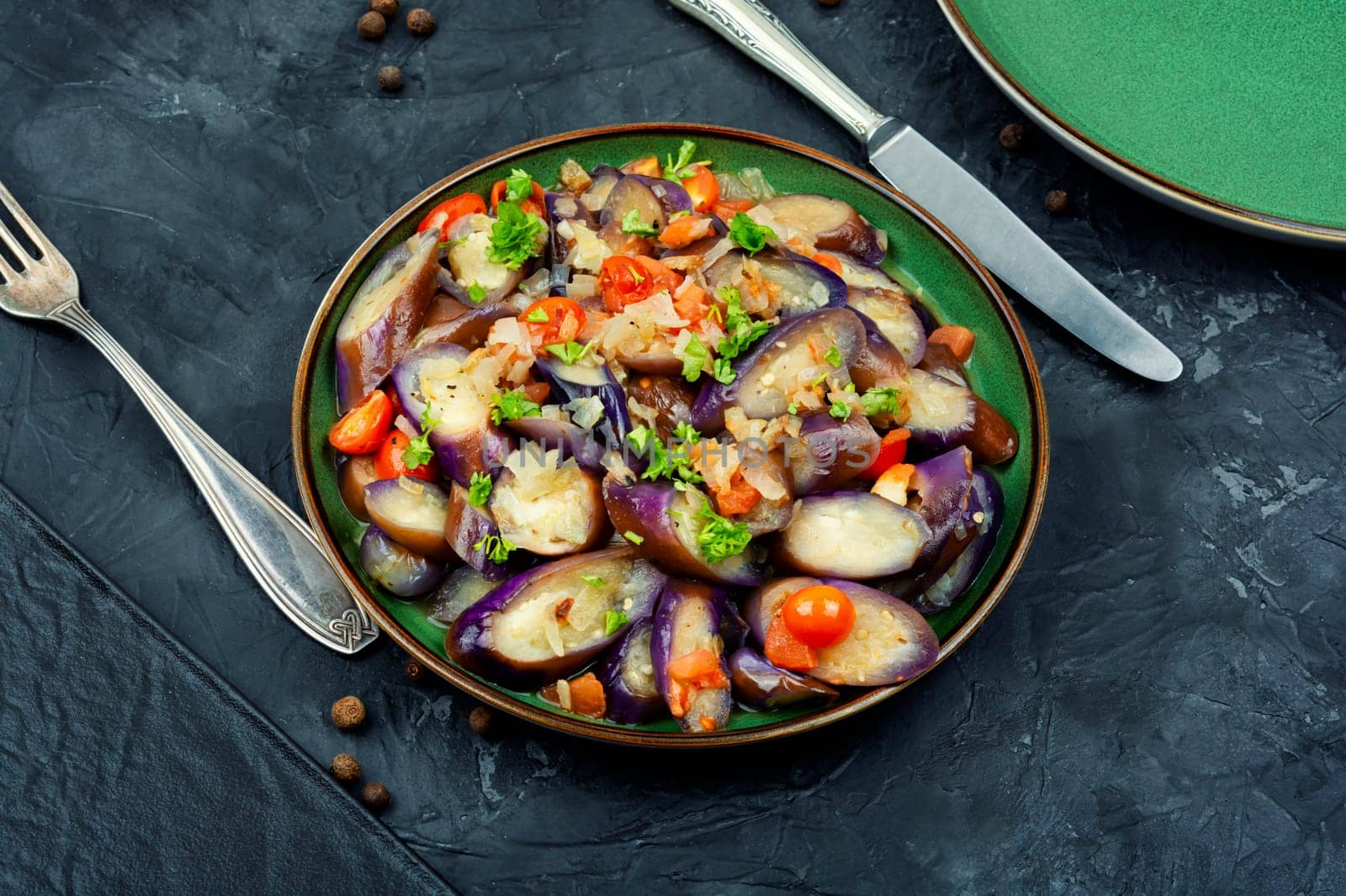 Grilled eggplant salad with parsley, garlic and tomato. Warm salad