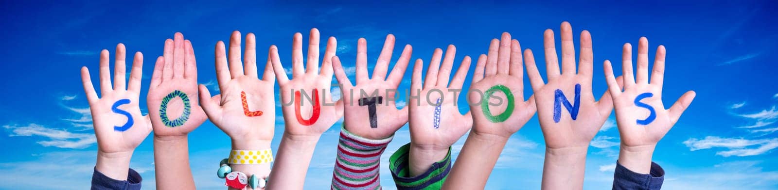Children Hands Building Colorful English Word Solutions. Blue Sky As Background