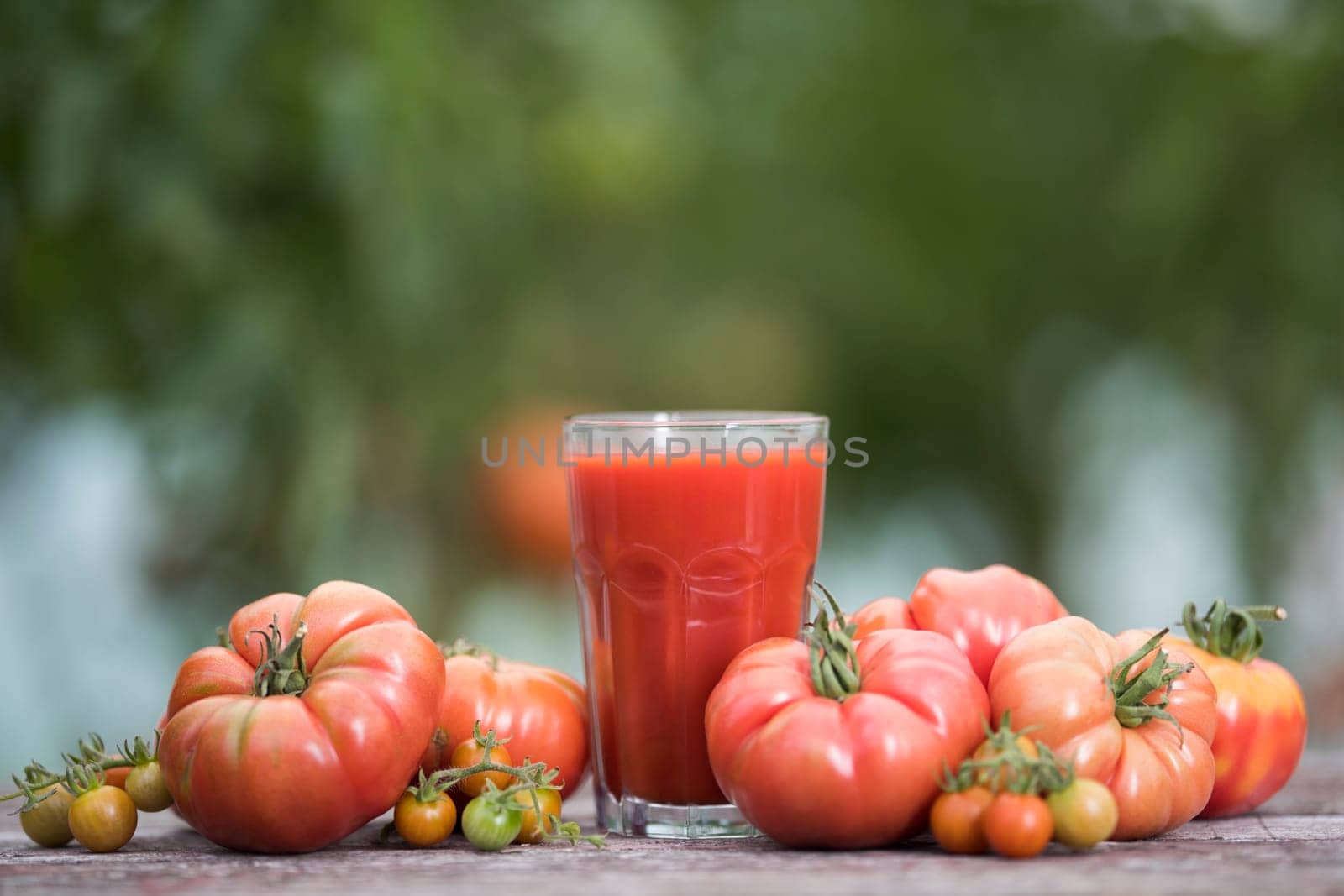 Fresh red tomato juice, on a wooden background