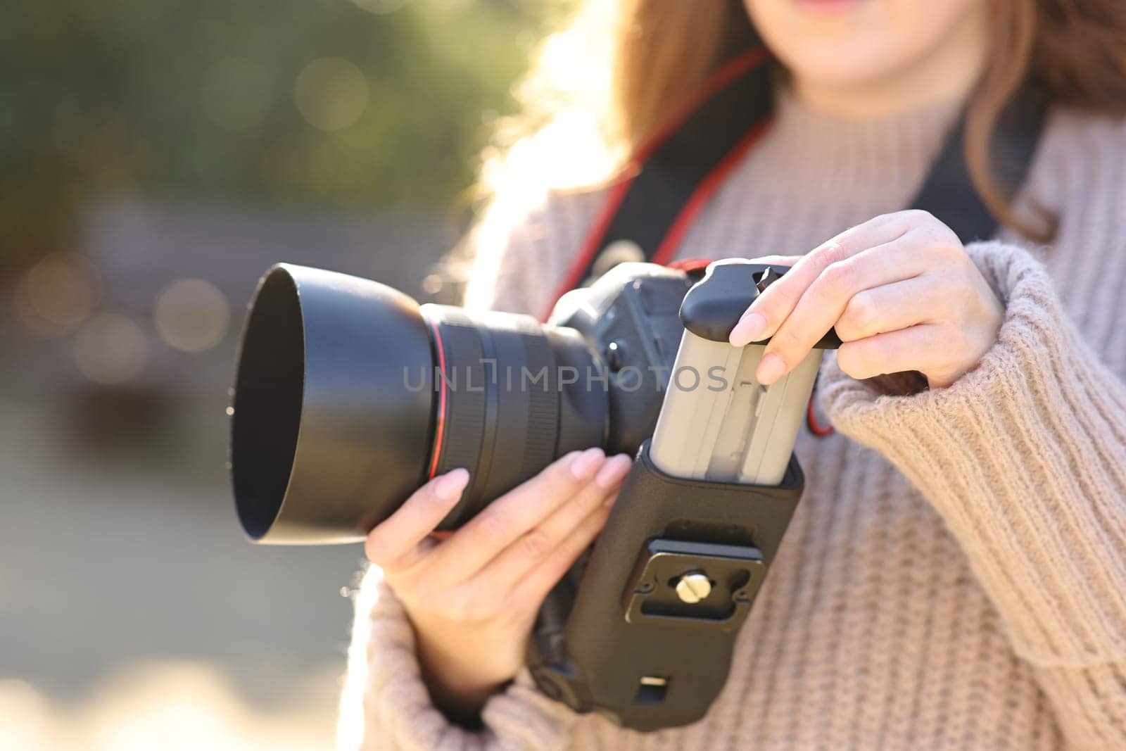 Close up of a photographer changing battery on dslr camera in winter