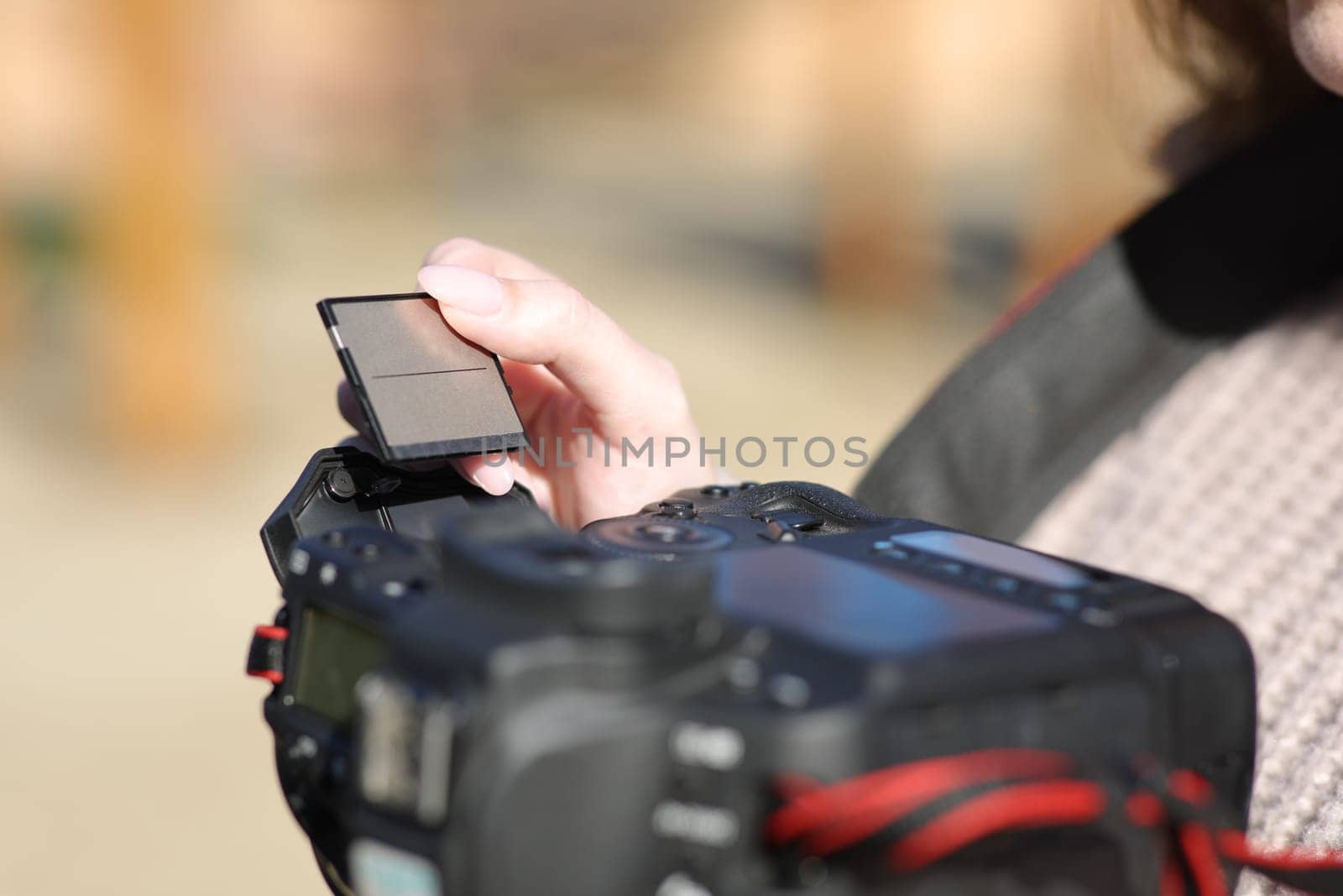 Close up of a photographer hand inserting compact card on camera