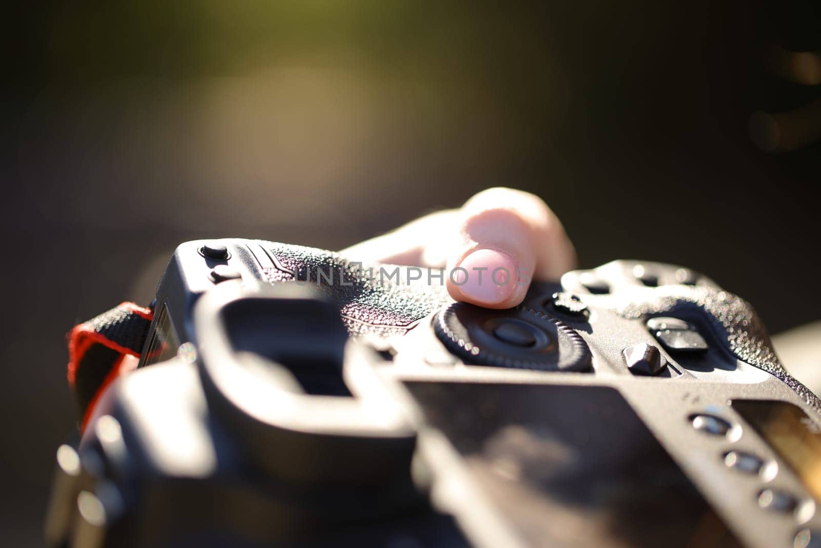 Photographer finger adjusting diaphragm aperture on camera dial