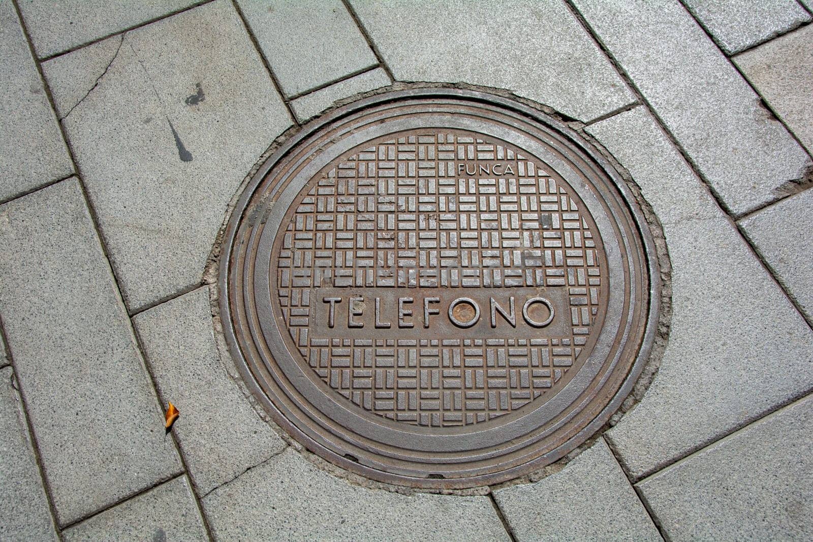 Costa Adeje, Tenerife, Spain August 12, 2022 - Manhole cover in a sidewalk