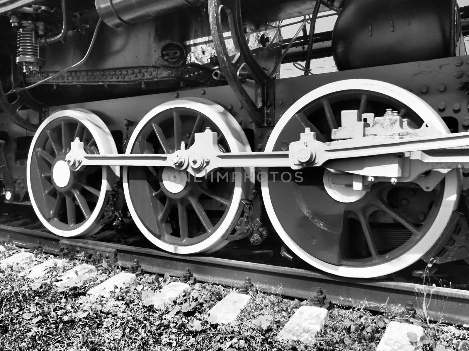 Retro train three wheels. Sleepers and rails, mechanisms, pistons and guides. Locomotive of the 19th early 20th century with a steam engine. Vintage style. Black - white photo. Beautiful card