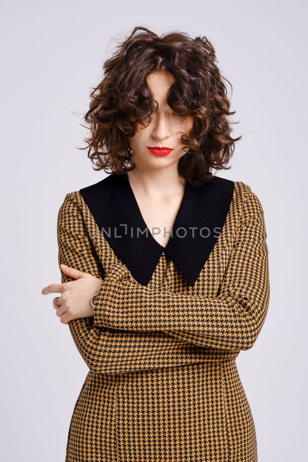 Studio portrait of tricky and playful woman with short curly hair