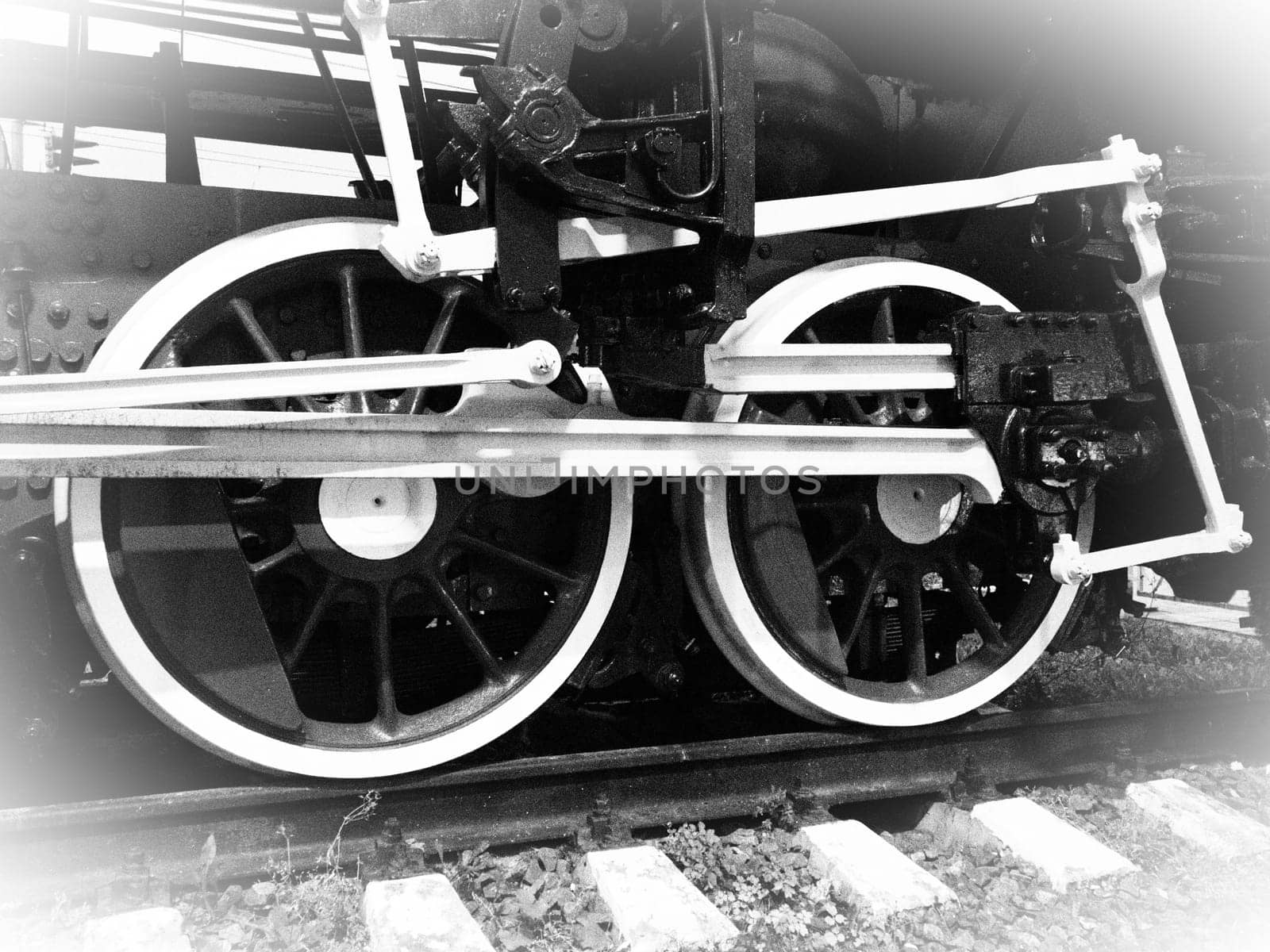 Retro train wheels. Beautiful card. Sleepers and rails, pistons and guides. Locomotive of the 19th early 20th century with a steam engine. Vintage style. Black-white. White vignetting around the edges.