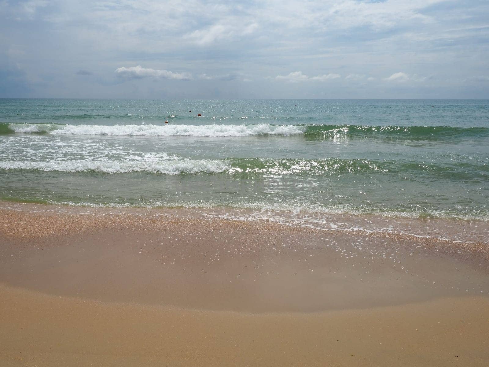 Summer sea with smooth waves blue sky sand and free space. Soft blue ocean wave or clear sea on clean sandy beach summer concept. Gorgeous Beach Landscape. Foam on sea water.