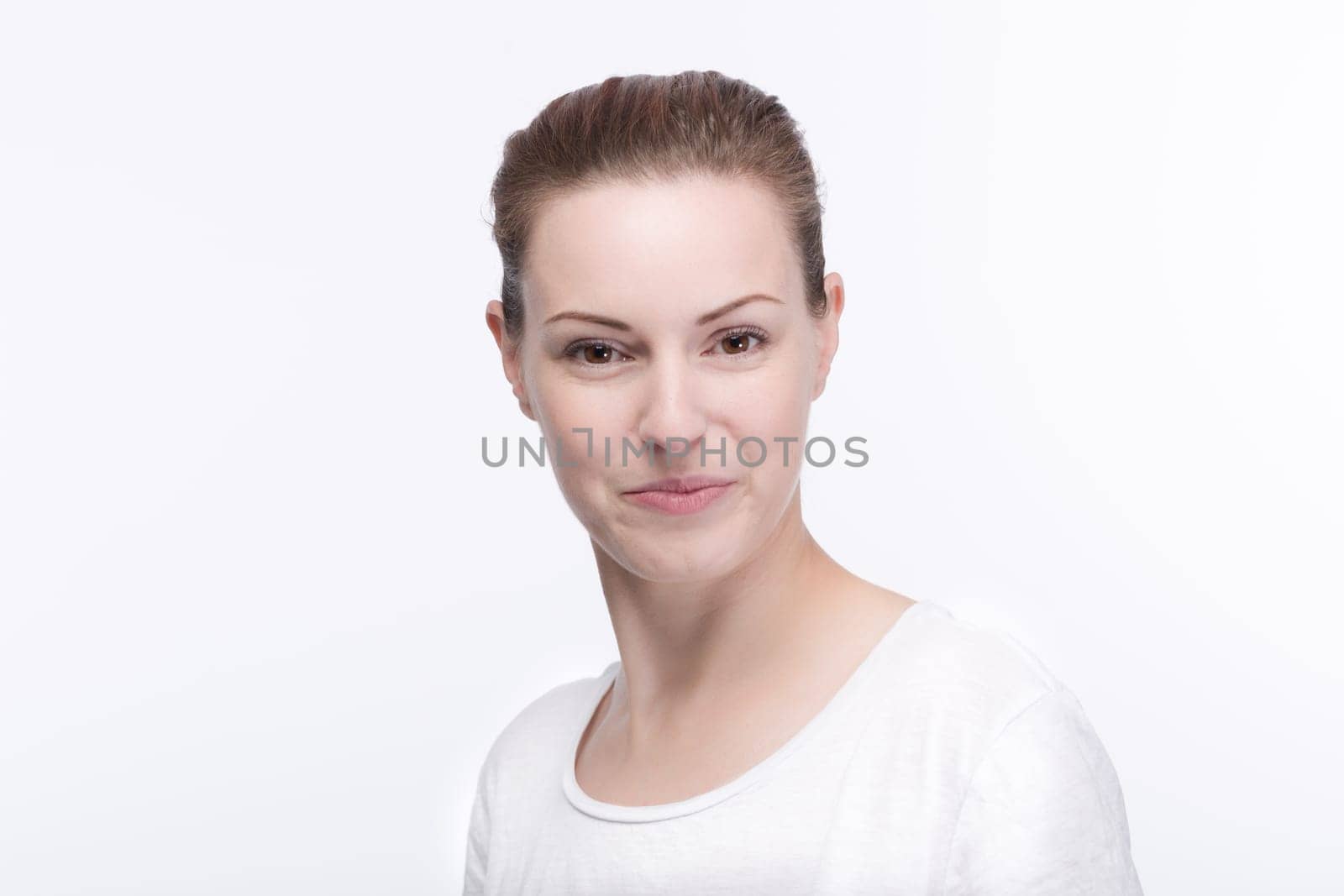 a young pretty woman in a white t-shirt smiles into the camera
