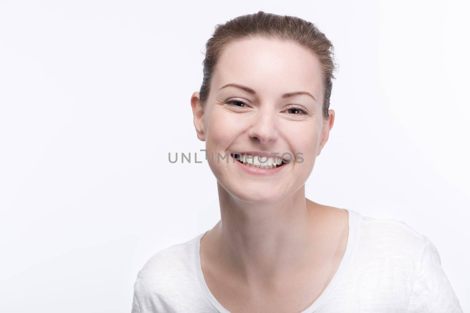 a young pretty woman in a white t-shirt smiles into the camera