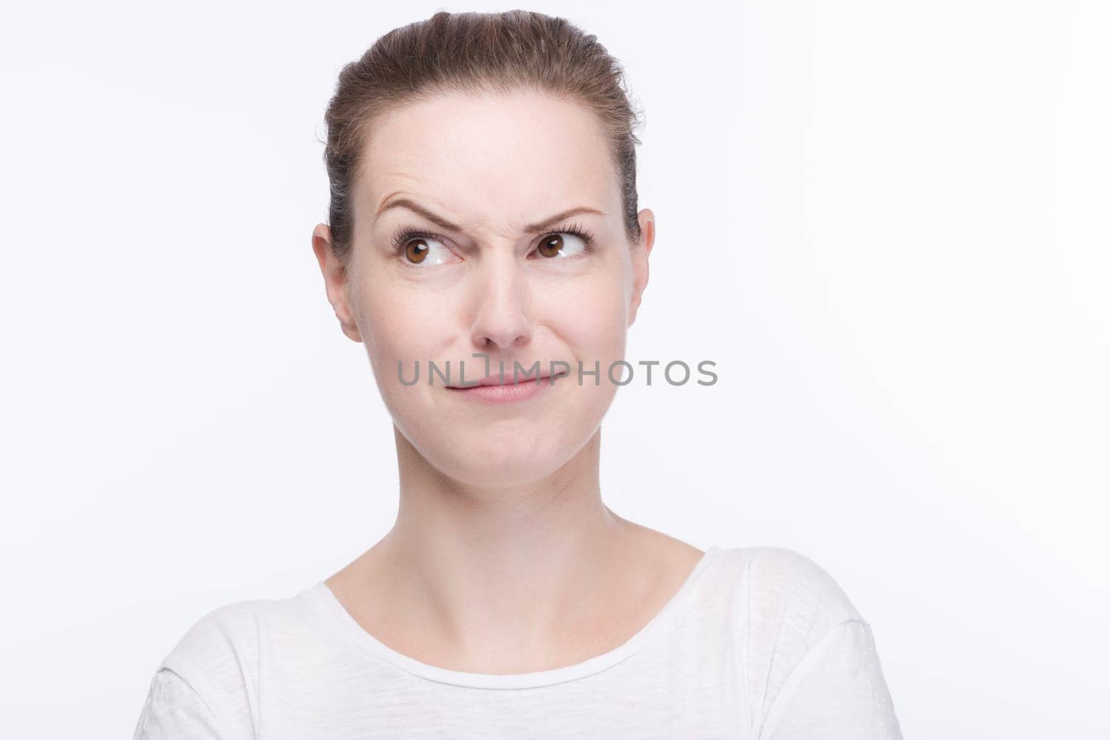 a young pretty woman in a white t-shirt thinks,thinks