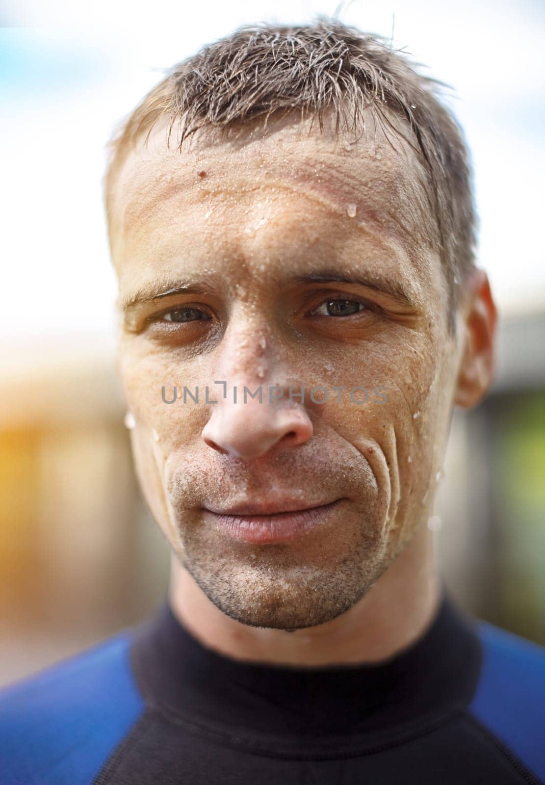 Portrait of a handsome young man in a diving suit. wet face with water drops close-up