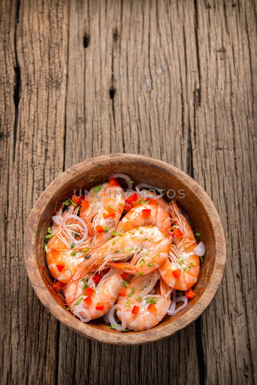 steamed shrimps in a wooden bowl on wood background