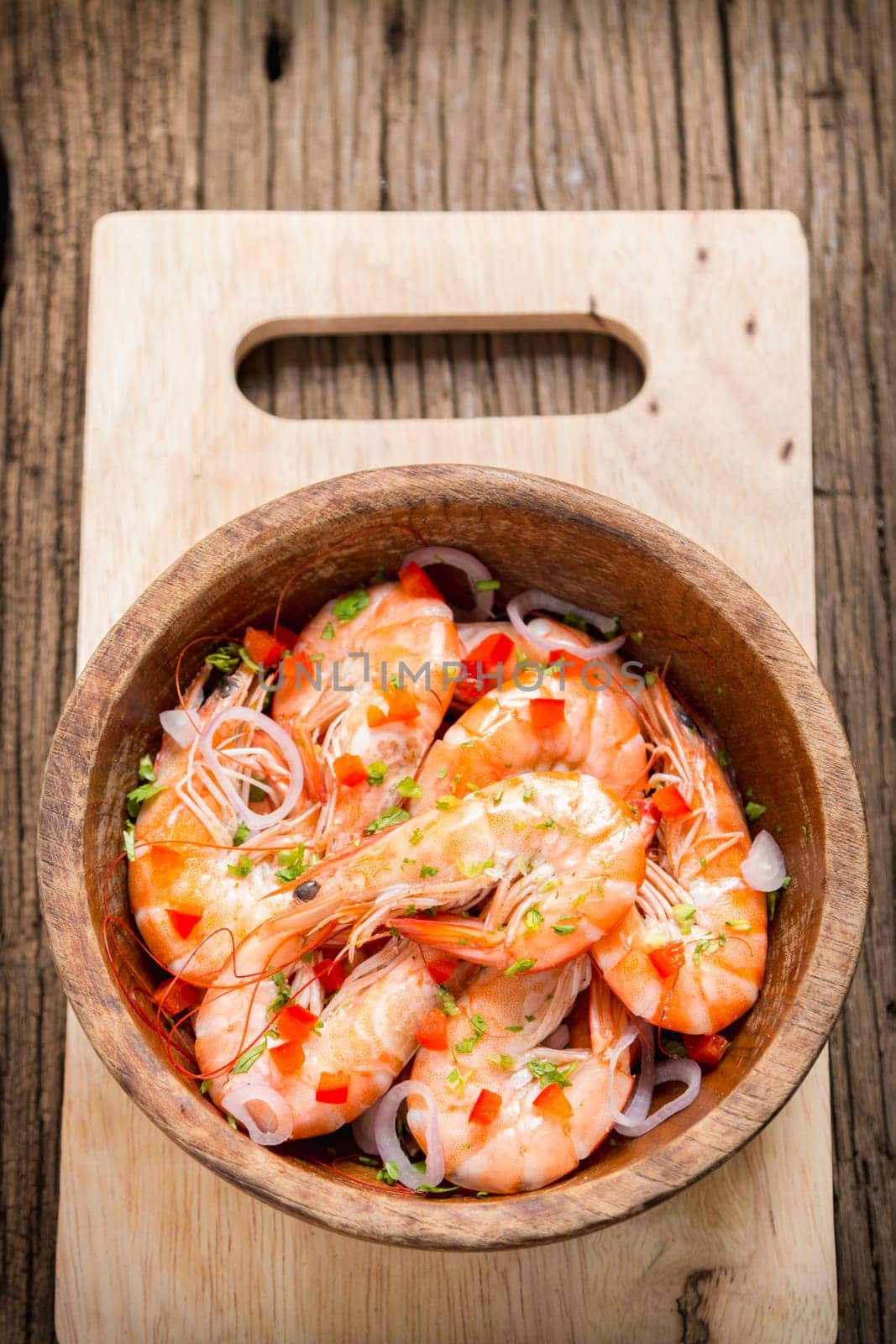 steamed shrimps in a wooden bowl on wood background