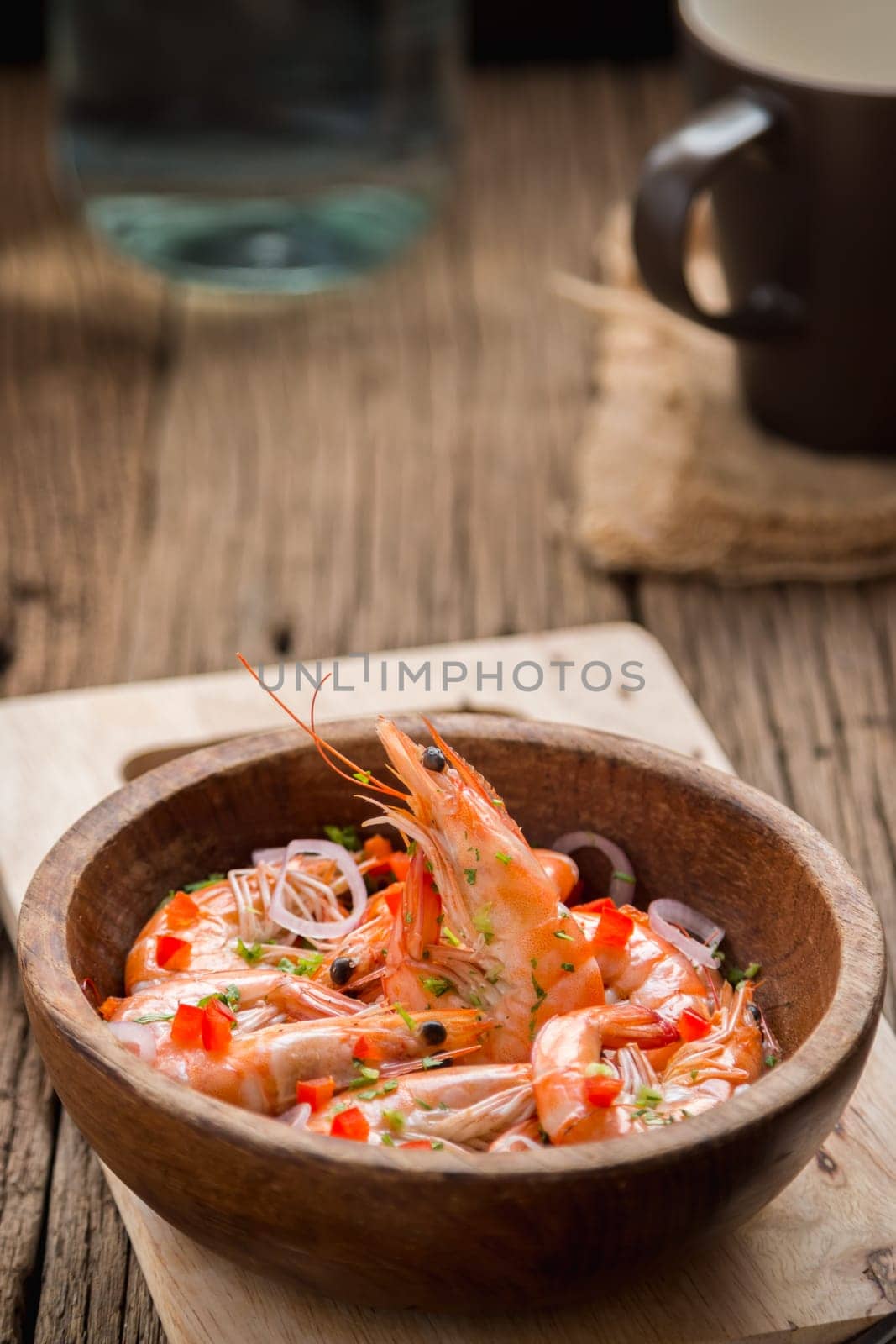 steamed shrimps in a wooden bowl on wood background