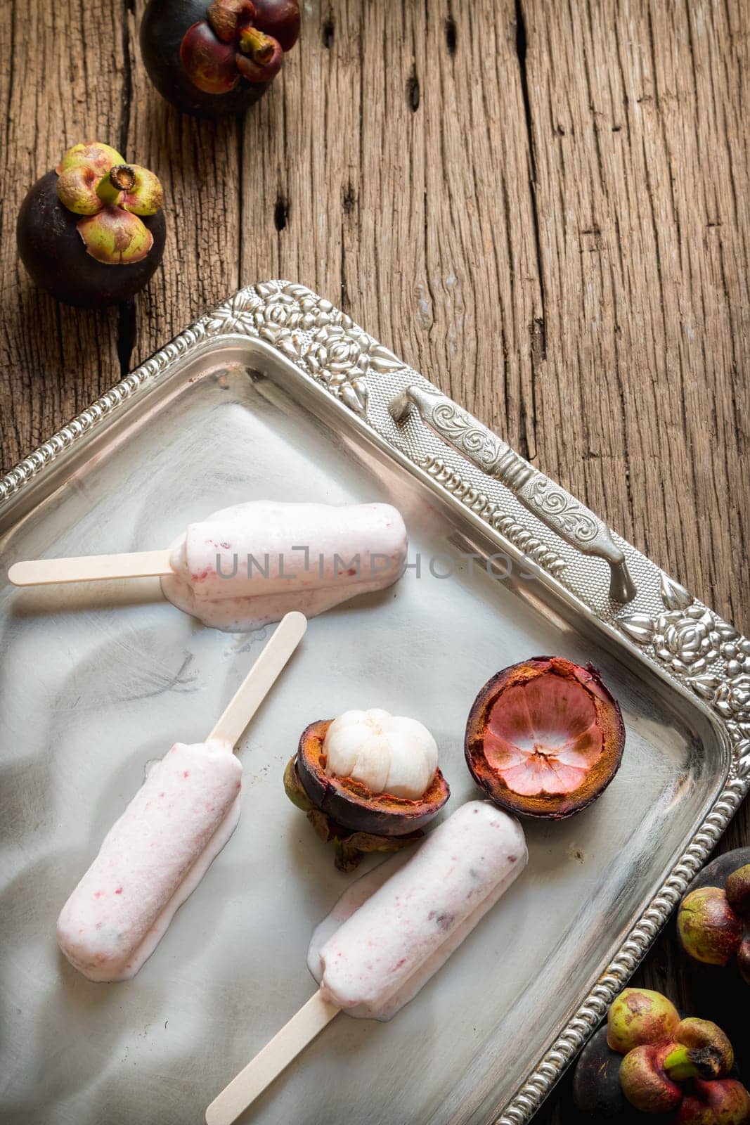 Ice cream containing mangosteen on a silver platter.