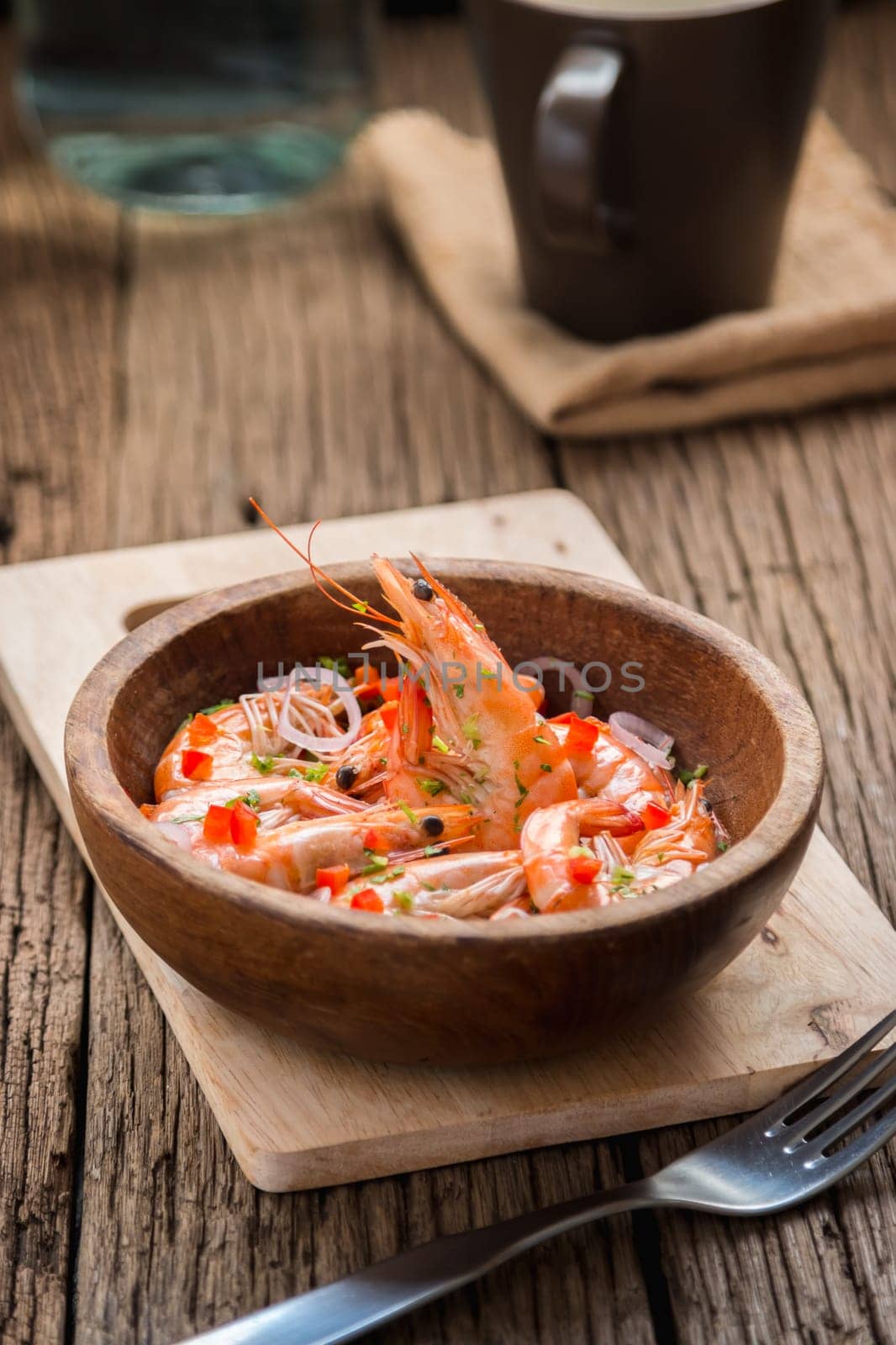 steamed shrimps in a wooden bowl on wood background