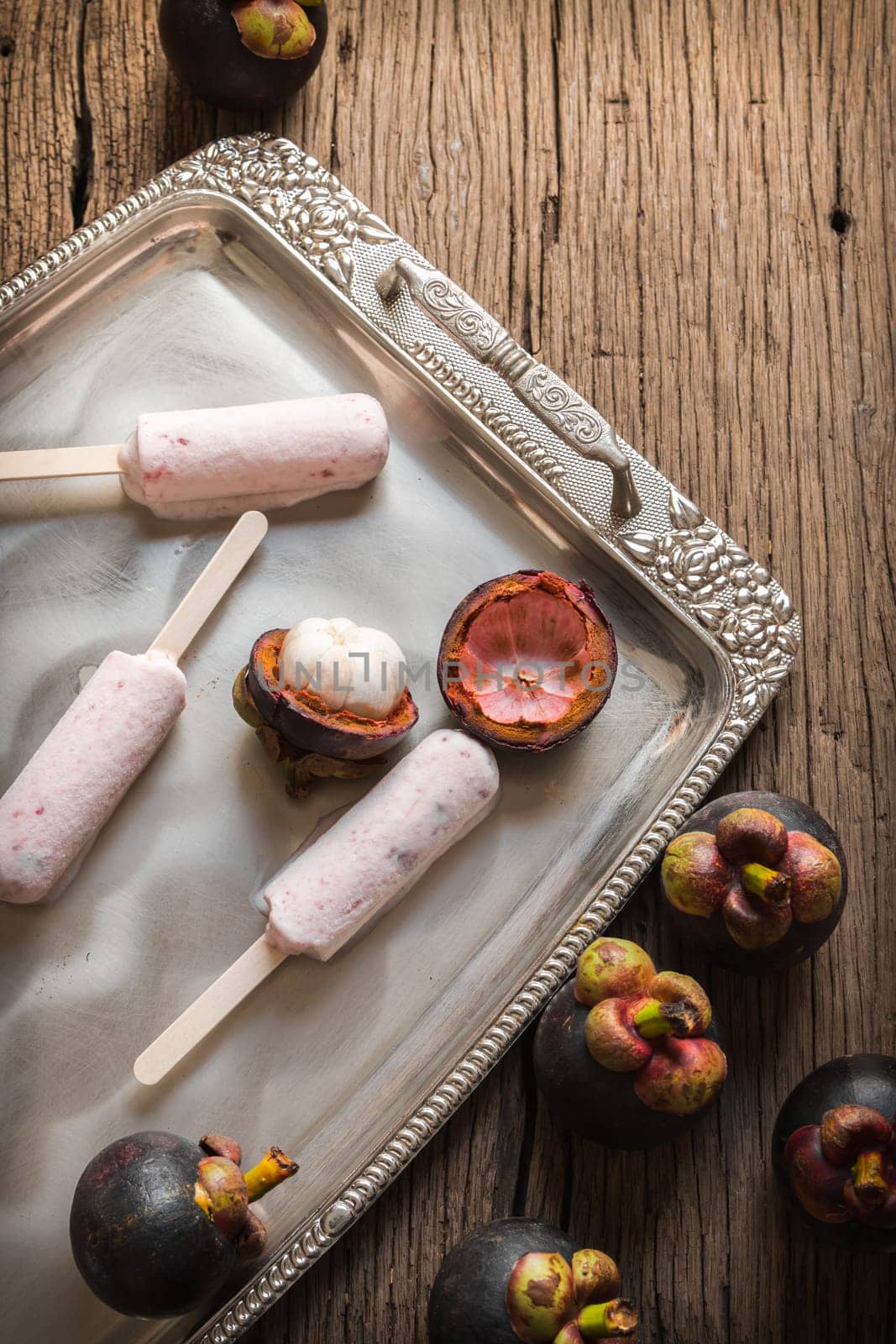 Ice cream containing mangosteen on a silver platter.