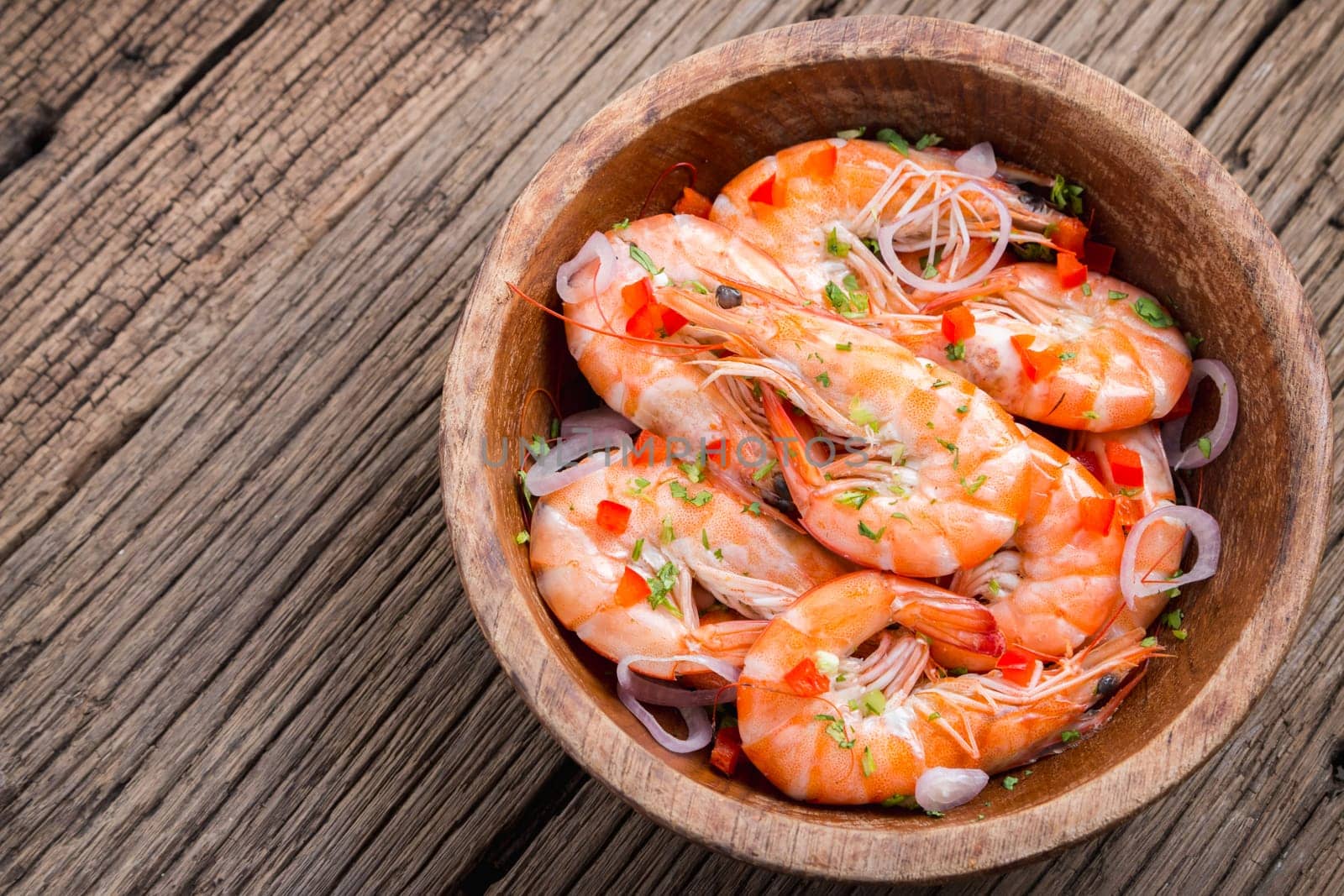 steamed shrimps in a wooden bowl on wood background