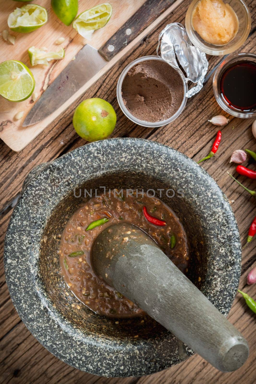 shrimp paste chilli sauce in a mortar stone with Ingredients to cook