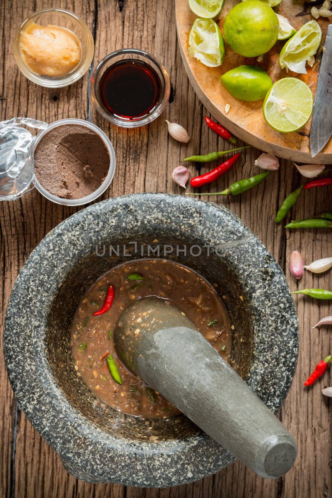 shrimp paste chilli sauce in a mortar stone with Ingredients to cook