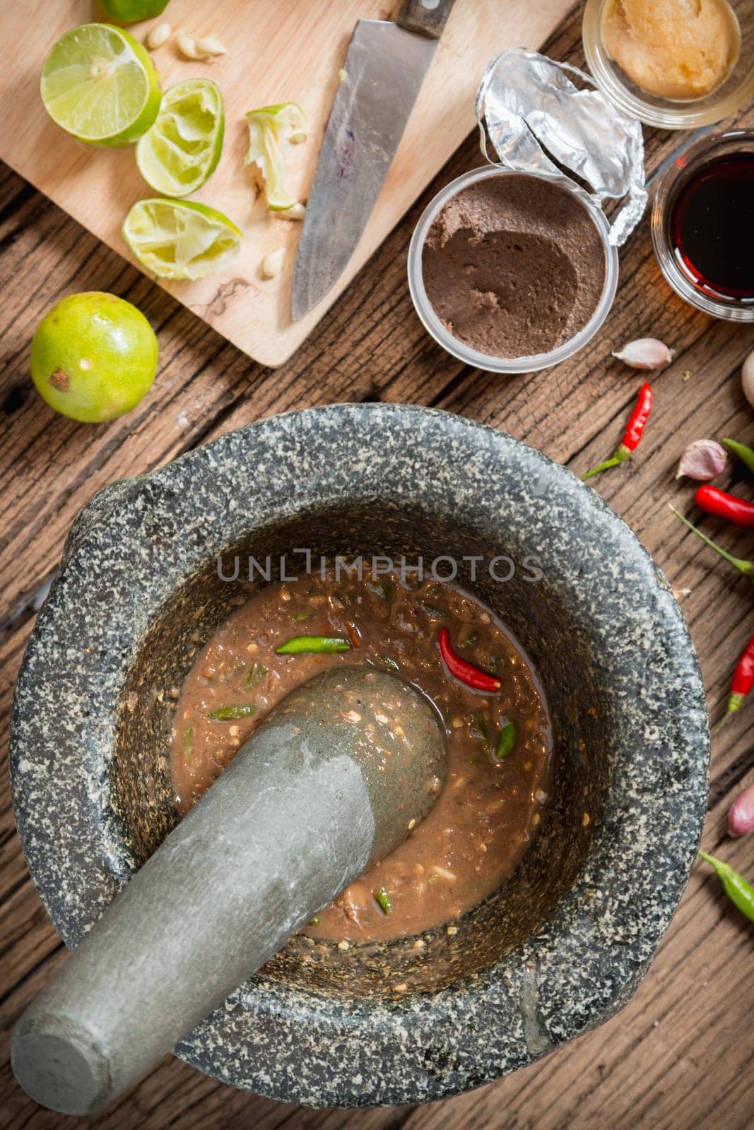 shrimp paste chilli sauce in a mortar stone with Ingredients to cook