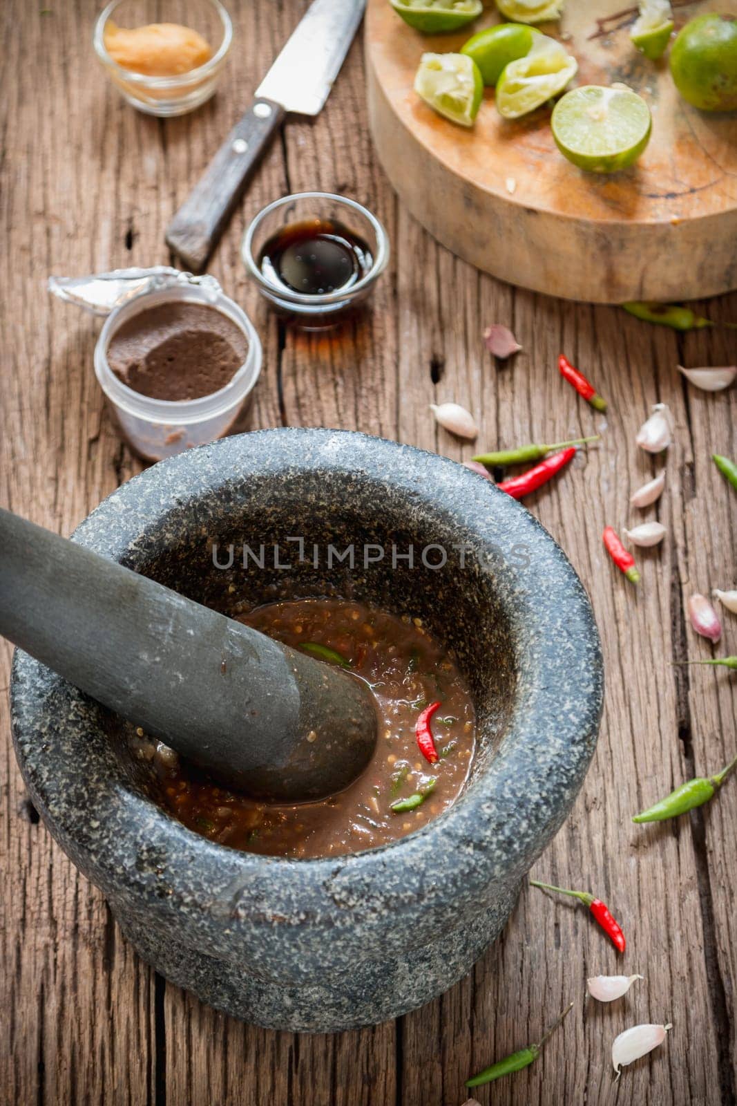 shrimp paste chilli sauce in a mortar stone with Ingredients to cook