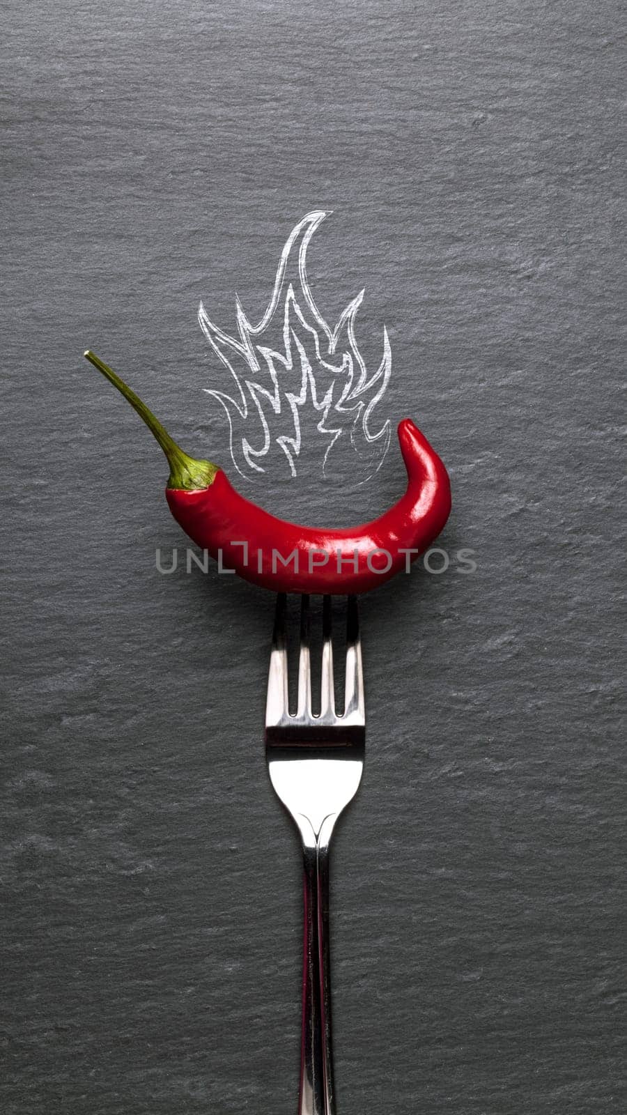 red chili pepper with fire and a black graphite background