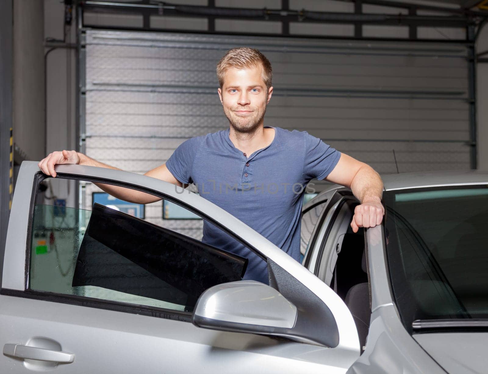 Applying tinting foil onto a car window in a workshop