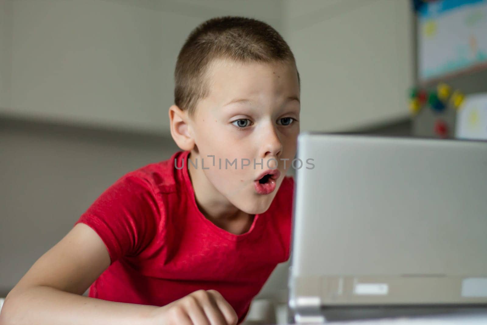 Boy 6-10 completes school lessons and homework online in the kitchen, looking at the tablet computer. The concept of distance education. Stay at home