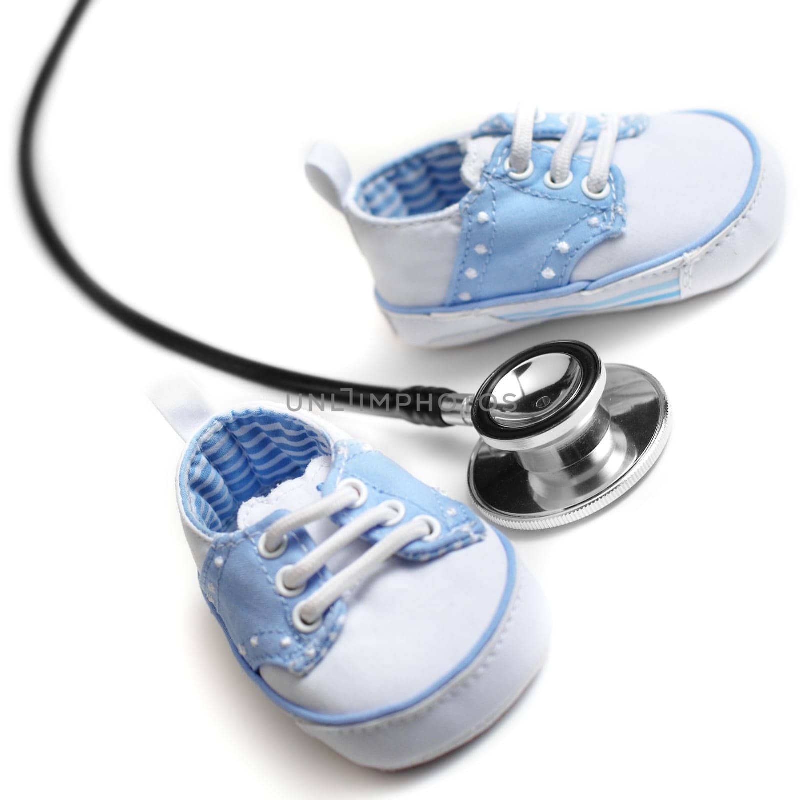 Baby shoes with stethascop against a white background.