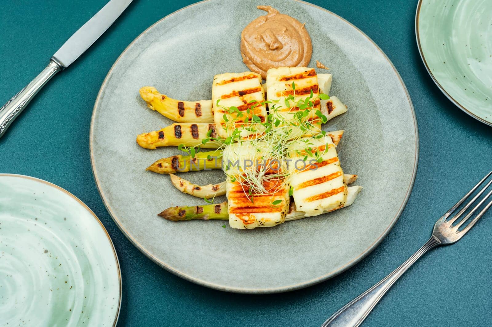 Appetizing appetizer of white asparagus and fried halloumi cheese.