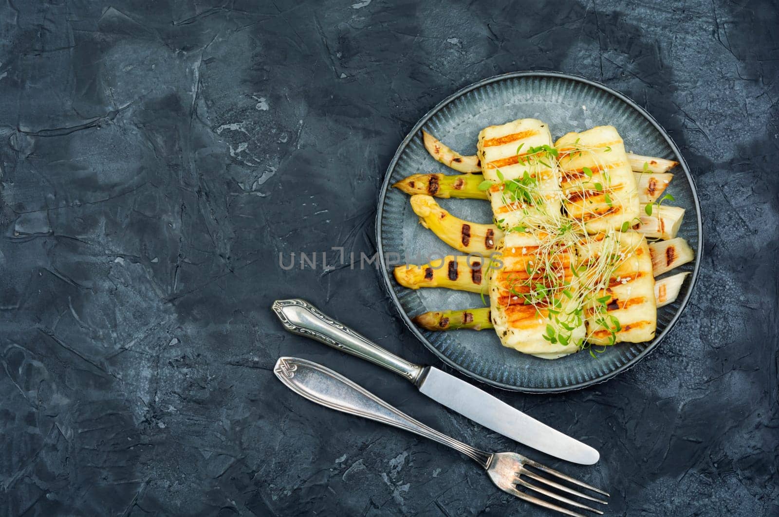Appetizing appetizer of white asparagus and fried halloumi cheese.
