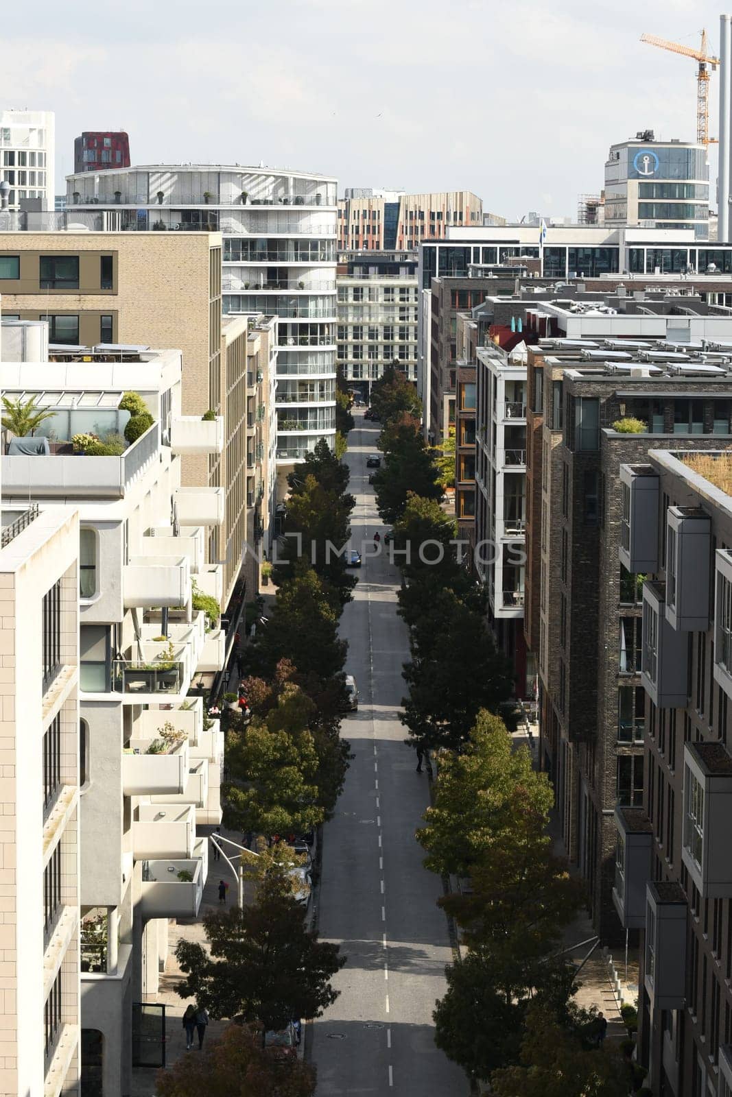 Vertical aerial view of Am Kaiserkai avenue buildings and trees on a sunny day in Hamburg, Germany