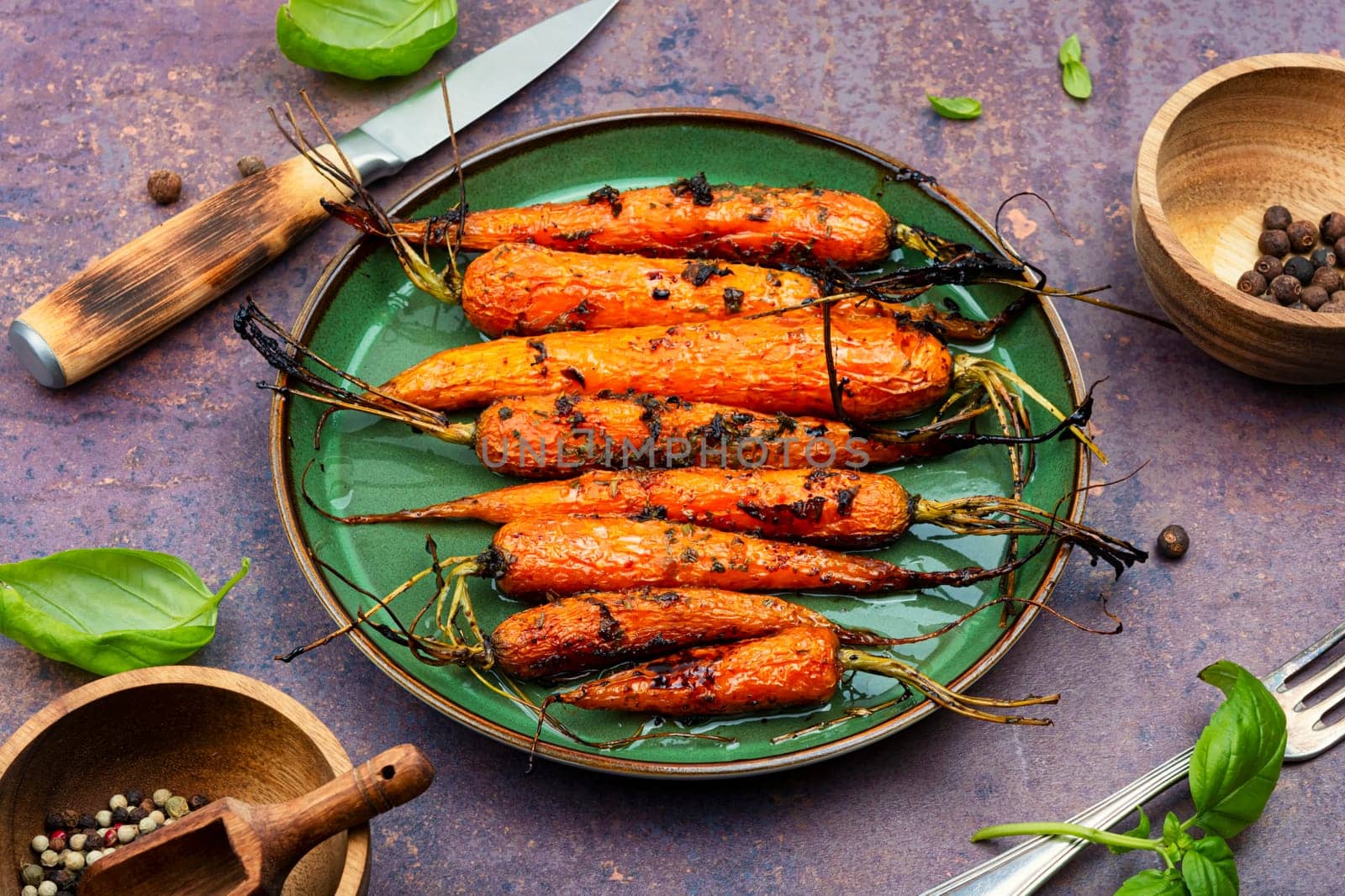 Baked with herbs and spices carrots. Tasty vegetable dish.