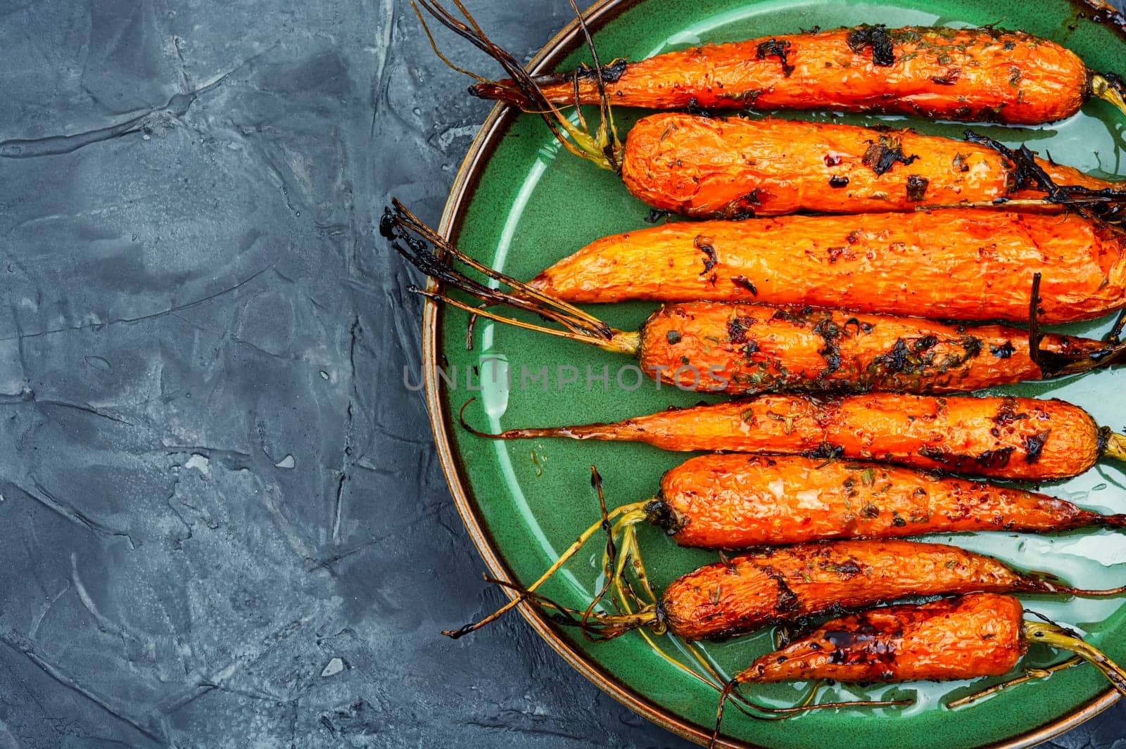 Baked with herbs and spices carrots. Tasty vegetable dish.