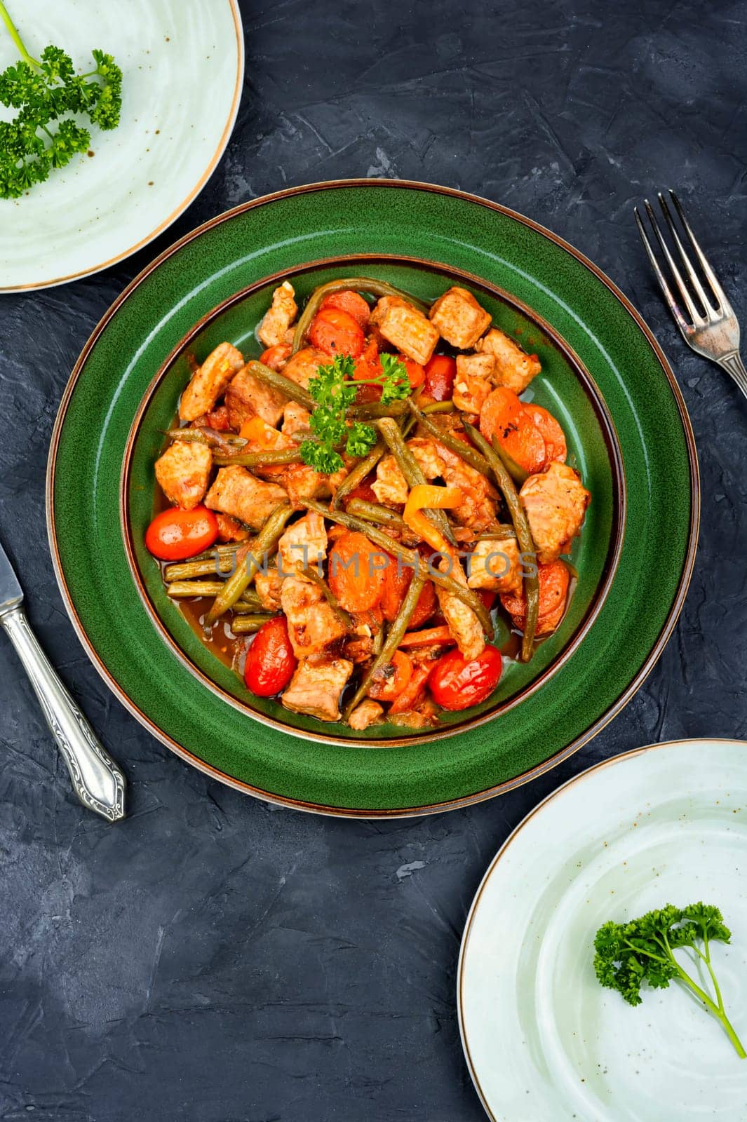 Stewed meat with carrots and green beans. Hot ragout with meat and vegetables.