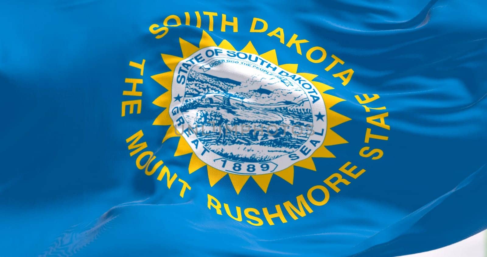 Close-up of South Dakota flag waving in the wind. Sky blue field with state seal and golden sun. US state. 3d illustration render. Close-up. Rippled textile