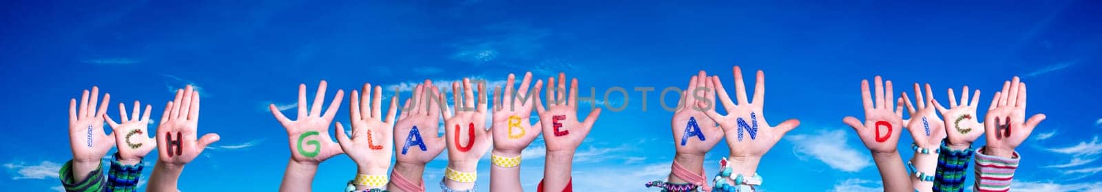 Children Hands Building Colorful German Word Ich Glaube An Dich Means I Believe In You. Blue Sky As Background.